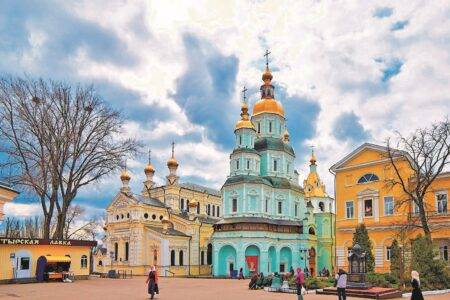 Свято-Покровський чоловічий монастир у Харкові з величним бірюзовим Покровським собором на тлі хмарного неба.